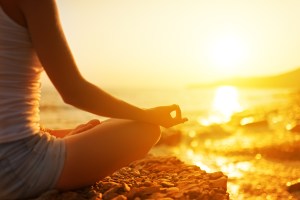 hand of  woman meditating in a yoga pose on beach